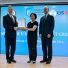美国驻越大使（左）向颁发越南富布赖特大学校长（左二）颁发援助决定。（图片来源：越通社） 