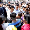 河内市人民委员会主席阮德钟与同心乡居民。（图片来源：越通社）