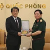 越南国防部部长吴春历向日本驻越南大使梅田邦夫赠送纪念品。（图片来源：越南人民军的报）