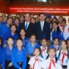 附图：越南政府总理阮春福与老挝总理通伦与两国青年代表合影。（图片来源：越通社）