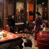 游客倾听升龙歌筹俱乐部成员介绍歌筹艺术。（图片来源：越南画报）