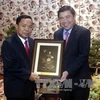 阮成峰（右）向老挝人民革命党中央办公厅主任坎潘·彭玛塔赠送纪念品。