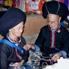 缝瑶族妇女交换挑选刺绣丝线的经验。
