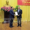 越共中央政治局委员、中央组织部部长范明政向张光义颁发​任命书。