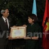 越南驻阿根廷大使邓春勇向阿根廷越南文化院授予越南友好组织联合会的奖状。（图片来源：越通社）