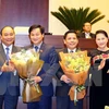 政府总理阮春福（左一）和国会主席阮氏金银（右一）向阮文体和黎明慨赠送鲜花。