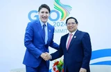 PM Pham Minh Chinh (R) shakes hands with his Canadian counterpart Justin Trudeau (Photo: VNA)