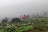 This grab taken from handout video footage released by Iranian Red Crescent Society (IRCS) on May 20, 2024 shows rescuers recovering bodies at the site of President Ebrahim Raeisi's helicopter crash in a fog-shrouded mountainous area of northwest Iran. (Photo: AFP/VNA) 