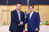 El primer ministro de Vietnam, Pham Minh Chinh y Cao Ronggen, presidente del Centro Internacional de Subastas de Flora de Kunming (KIFA) (Fuente: VNA)