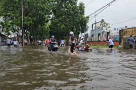 Workers wade through floodwater at the Giao Long Industrial Park in Chau Thanh district, Ben Tre province, due to heavy rains during May 20 night and early May 21. (Photo: VNA)