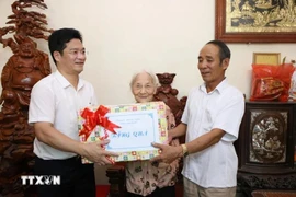Standing Vice Chairman of the Nam Dinh provincial People's Committee Tran Anh Dung (first, left) presents a gift to Heroic Vietnamese Mother Tran Thi Chuc (centre), born in 1925, in My Thang commune of My Loc district. (Photo: VNA)