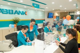 Customers make transaction at an ABBank office. The draft circular requires banks to carry out annual security and confidentiality inspections and assessments of the online banking system. (Photo: cafef.vn)