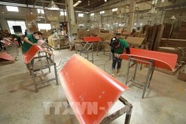 Workers put final touches on wood planks for export at a factory in An Dien commune of Ben Cat district, Binh Duong province. (Photo: VNA)