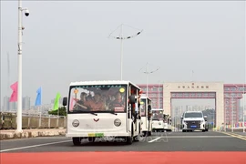 Electric vehicles carrying tourists cross Bac Luan II Bridge, part of the Mong Cai (Quang Ninh, Vietnam) - Dongxing (Guangxi, China) international border gates. (File photo: VNA)