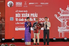 VNA General Director Vu Viet Trang (left) and Vice Chairman of the Hanoi People’s Committee Ha Minh Hai (right) presents the Grand Prize of the “Bui Xuan Phai: For the Love of Hanoi” Awards to architect Hoang Dao Kinh at the ceremony on October 8. (Photo: VNA)