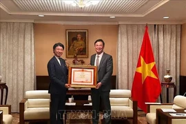 Vietnamese Ambassador to Japan Pham Quang Hieu (right) presents Prime Minister Pham Minh Chinh's Certificate of merit to Yoichiro Aoyagi, a member of the Japanese House of Representatives, for his contributions to Vietnam-Japan relations. (Photo: VNA)