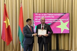 L'ambassadeur du Vietnam en Biélorussie Nguyen Van Ngu (gauche) remet des satisfecit à des Biélorusses ayant de nombreuses contributions au renforcement de l'amitié entre les deux pays. Photo: VNA