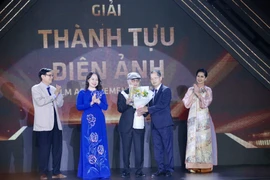 La vice-présidente Vo Thi Anh Xuan (2e de gauche à droite) remet le "Cinema Achievement Awards" au réalisateur Dang Nhat Minh (3e, droite). Photo: VNA 
