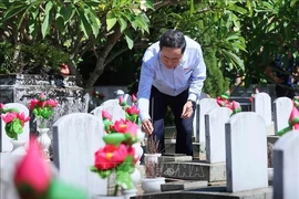 Le président de l'Assemblée nationale, Tran Thanh Man, offre de l'encens sur les tombes des martyrs au cimetière international des Morts pour la Patrie Vietnam - Laos. Photo: VNA
