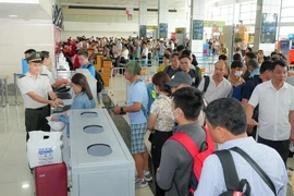 Le personnel de la sécurité aérienne vérifie les documents des passagers. Photo: Vietnam+