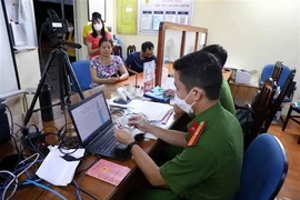 La police de la commune de Yen Thuong, district de Gia Lam, à Hanoï, aide les habitants à effectuer les procédures d'enregistrement de la carte d'identité à puce. Photo: VNA