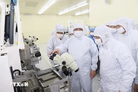 El primer ministro Pham Minh Chinh visita la línea de producción de chips semiconductores de la empresa Hana Micro Vina (Foto: VNA)