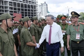 El presidente To Lam y miembros de la fuerza que participa en las tareas de protección de seguridad y orden a nivel de base de Ciudad Ho Chi Minh. (Fuente:VNA)