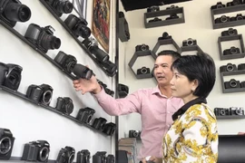 A visitor learns about the cameras on display at Like Coffee and Tea on Le Hong Phong Street, Nga Bay City, Hau Giang Province, southern Vietnam. (Photo: Tuoitre.vn)