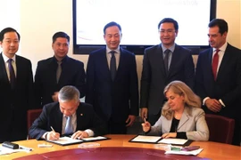 Nguyen Quoc Huy, director general de SCIC, y Michal Ron, en representación de SACE, firmaron el MoU sobre cooperación entre las dos partes. (Fuente: VNA)