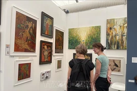 越南画作吸引外国参观者的关注。图自越通社