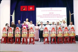胡志明市越南祖国阵线委员会副主席范明俊向各位代表赠送礼物。图自越通社