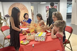 法国儿童在“Bonjour——越南你好!”文化节上参加体验活动。图自越通社