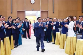 Le Premier ministre Pham Minh Chinh (au milieu) rencontre des entrepreneurs exemplaires vietnamiens à l'occasion de la Journée des entrepreneurs vietnamiens (le 13 octobre). Photo : VNA