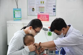 Un petit enfant s'est fait vacciner contre la rougeole au poste médical du quartier Phuoc Long A (ville de Thu Duc). Photo : VNA