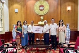 Le 27 septembre, au siège du Comité central du Front de la Patrie à Hanoï, Tang Tuan Tu ( gauche), président de l'Association vietnamienne au Royaume-Uni a remis 100 millions de dongs pour soutenir la population sinistrée. Photo : VNA