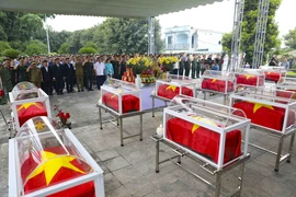Memorial and burial service held for the remains of 12 Vietnamese volunteer soldiers and experts who laid down their lives in Laos. (Photo: VNA)