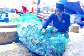 A fisherman brings plastic waste from his boat to shore (Photo: VNA)