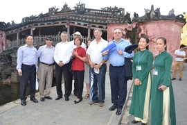 Representatives of twin cities - Hoi An and Szentendre, Hungary - share a photo at the Japanese Bridge in the ancient town. (Photo: VNA)
