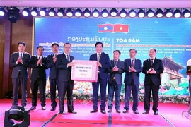 Nguyen Huy Hoang, Director of the Son La Department of Education and Training, presents gifts to representatives of the departments of education and sports from the seven Lao provinces at the seminar. (Photo: VNA)