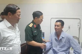 Lieutenant General Pham Truong Son visits Senior Lieutenant Colonel Nguyen Hong Quan, chief flight instructor of Air Force Regiment 940 and one of the two pilots involved in the plane crash, at the hospital on November 7. (Photo: VNA)