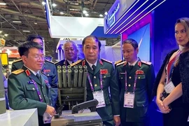 Delegación del Ministerio de Defensa de Vietnam visita un stand en la exposición (Foto: QDND)
