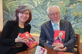 Author Cho Chul-hyeon (R) presents a copy of his book to a Vietnam News Agency reporter in Seoul. Photo: VNA)