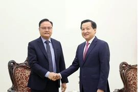 Deputy Prime Minister Le Minh Khai (R) and Lao Minister of Finance Santiphab Phomevihane. (Photo: VNA)