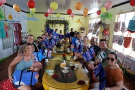 Foreign tourists are excited to use bags made from plastic tarpaulin by Green Life Ha Long Cooperative in Quang Ninh. (Photo: VNA)