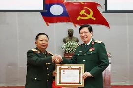 Lao Deputy Prime Minister and Minister of National Defence Gen. Chansamone Chanyalath presents a first-class Labour Order to VMMU Director Nguyen Xuan Kien. (Photo: VNA)