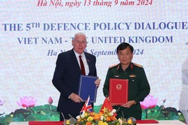 Sen. Lieut. Gen Hoang Xuan Chien and UK Minister of State for Defence Vernon Coaker sign minutes of the dialogue (Photo: VNA)