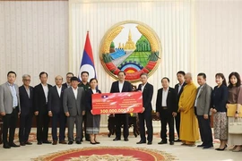 The delegation of the Vietnamese community in Laos presents to the Lao side a token of their aid for those affected by Typhoon Yagi in the country’s northern region. (Photo: VNA)