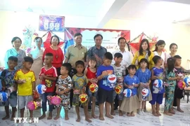 The organising board hands over Mid-Autumn Festival gifts to children of Vietnamese origin in the capital of Phnom Penh. (Photo: VNA)