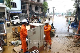 EVN staff repairing flooded transformer on Chuong Duong Do street, Hoan Kiem district, Hanoi, before power restoration. (Photo: VNA)