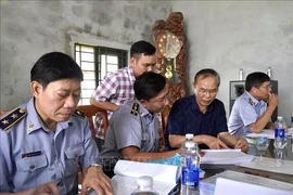 A working delegation from the Ministry of Agriculture and Rural Development led by its Deputy Minister Phung Duc Tien (second from right) inspects the traceability records of aquatic products at Cua Viet fishing port in Quang Tri province. (Photo: VNA)